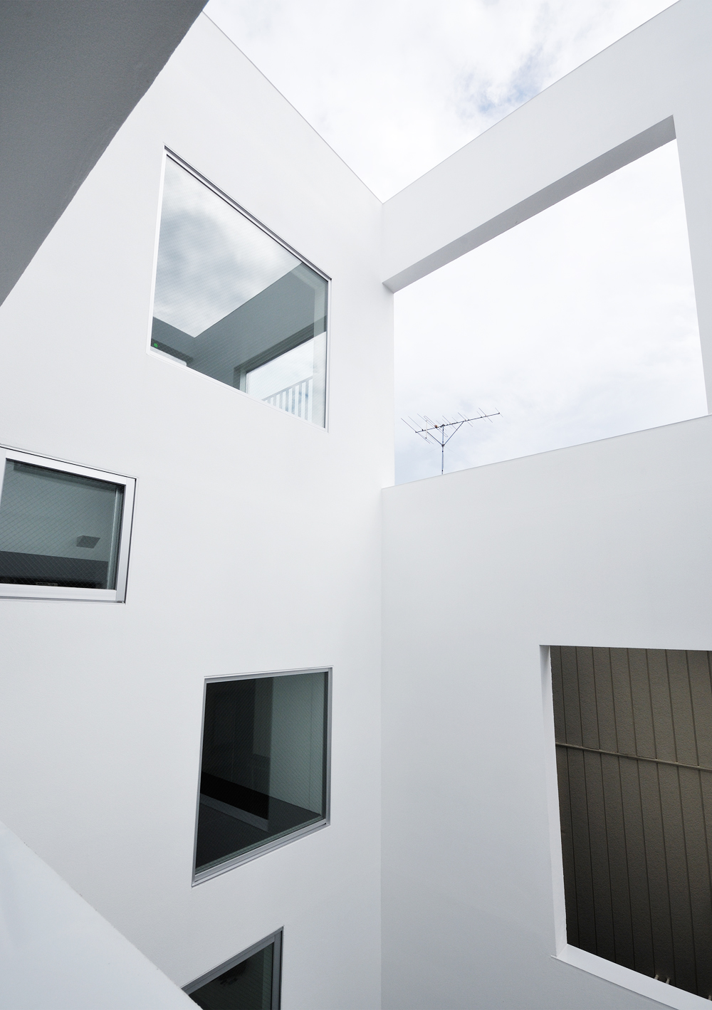 四角い窓がランダムに並ぶ、額縁のような装いの外壁