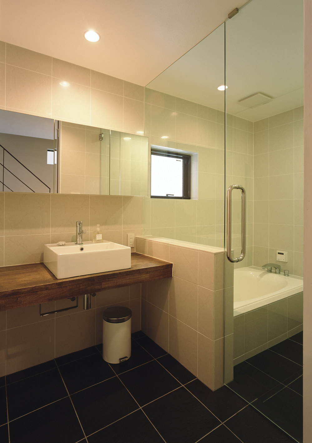 目地の少ないすっきりとした印象を与える、大きめのタイルを用いた洗面所・浴室