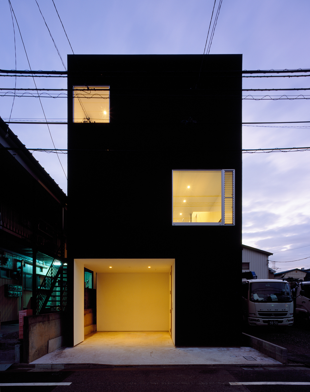 夜の光が黒い外壁を柔らかな印象に変える外観