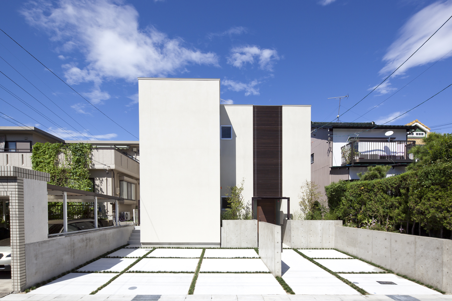 南側に開かないことで強烈な日射を遮り、壁沿いに光を内部に入るようにした外観