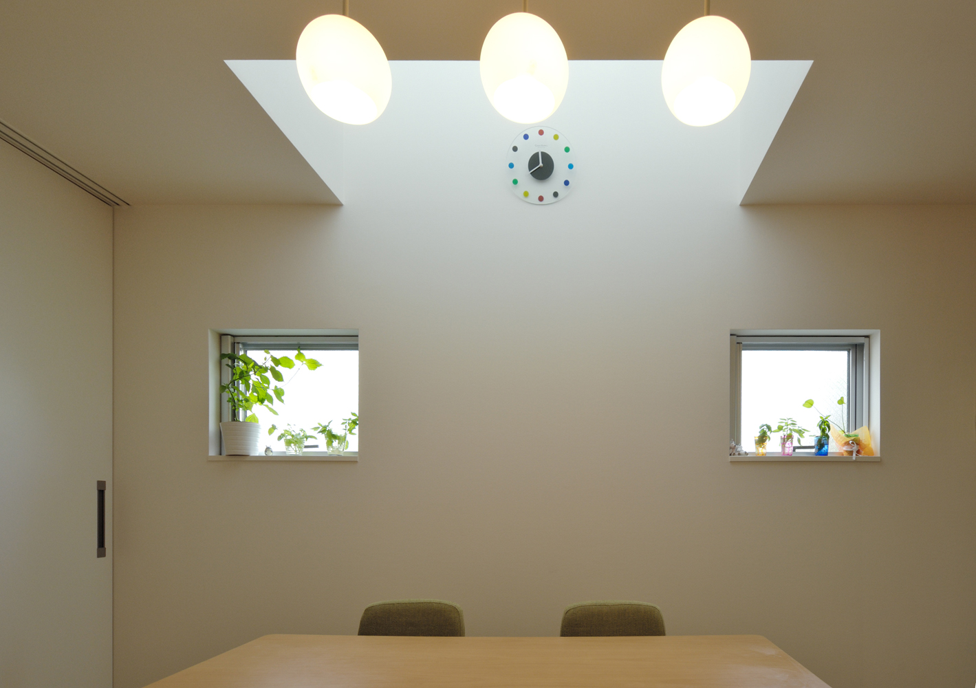 四角い窓と丸い照明が、シンプルかつ優しい雰囲気にさせるダイニング