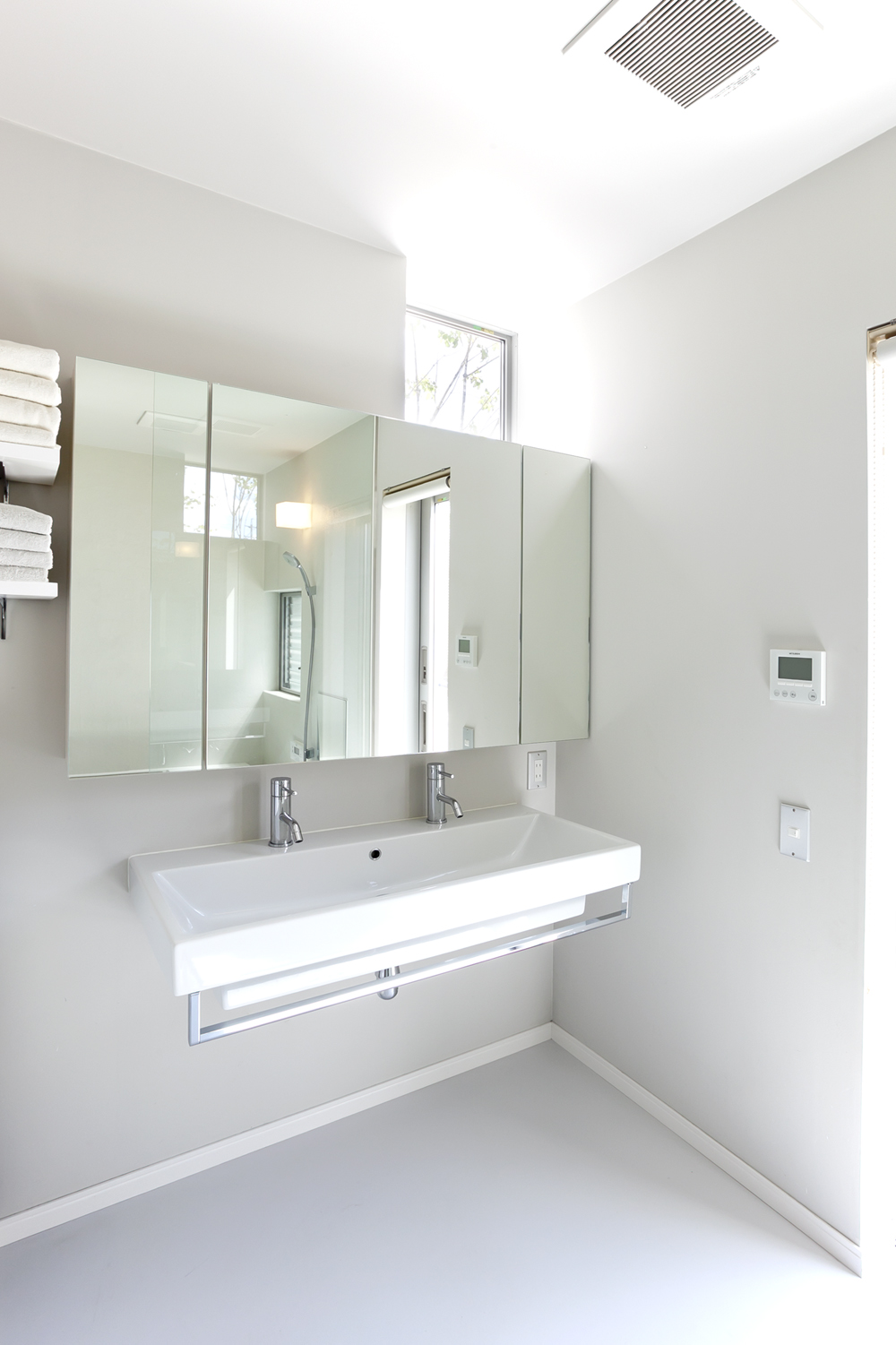 高窓から、ほど良い光と中庭の緑を見ることができる清潔感ある洗面所