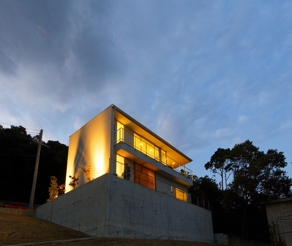 木目のルーバーが印象的な動きのある夜の外観