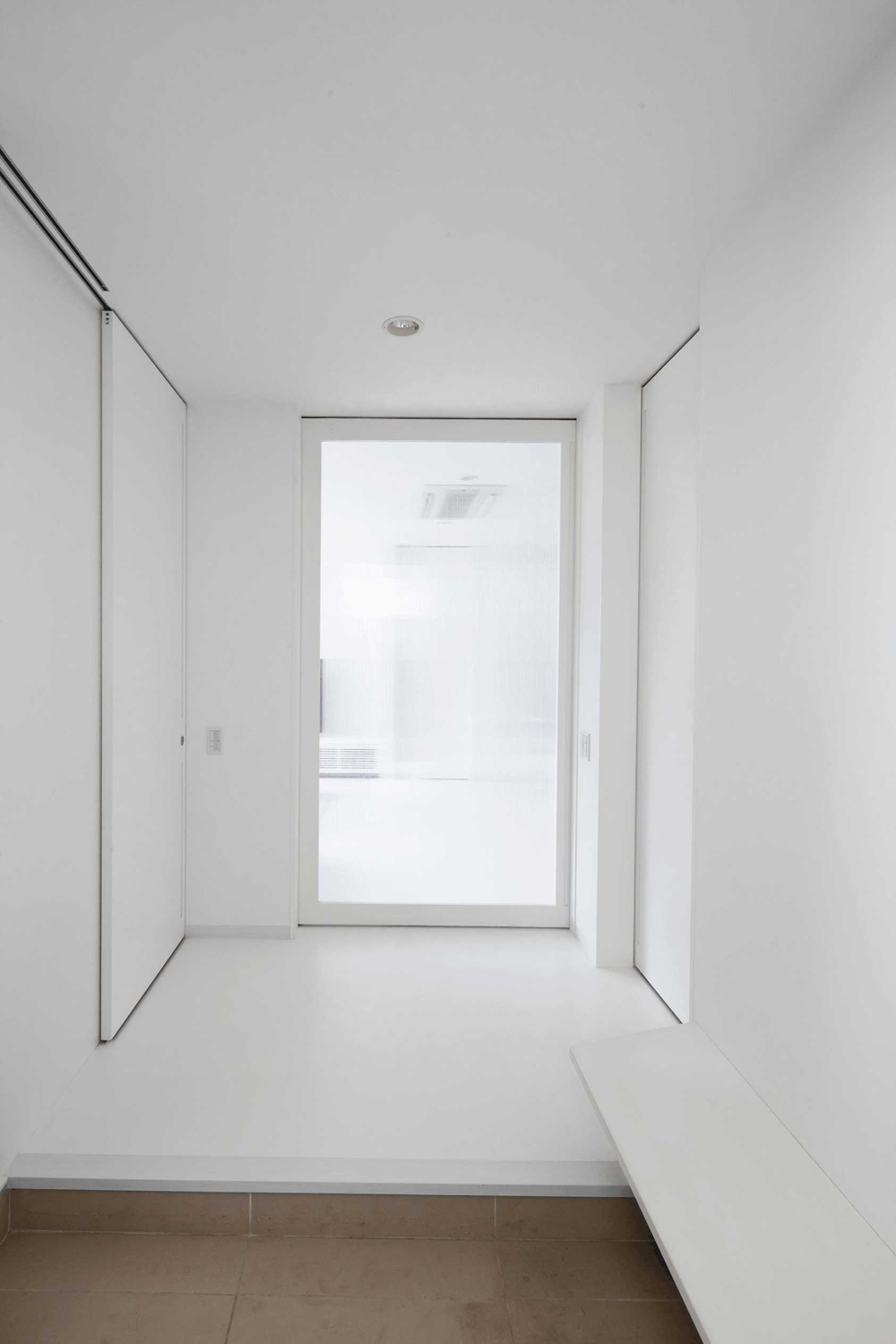 正面先はツインカーボ建具を使用し、プライバシーを確保しつつ窓のない玄関に光をもたらしている