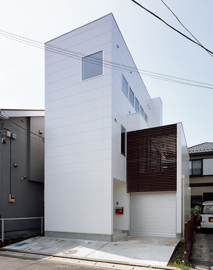 白い外壁に木の格子が美しい外観