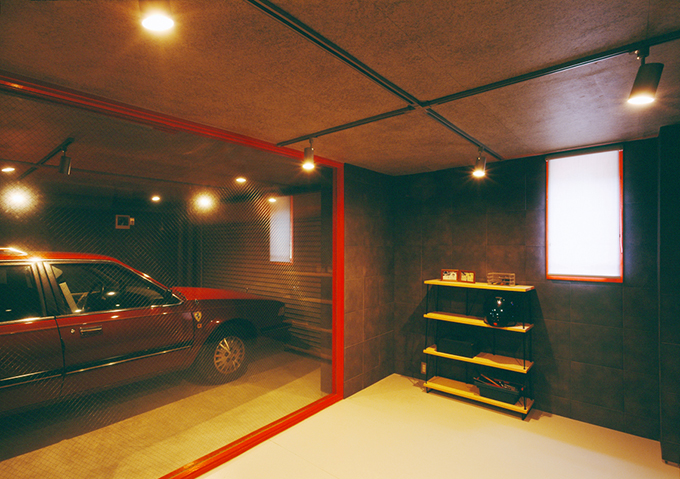 赤の建具が印象的なガレージを望む部屋