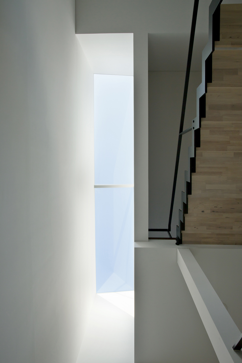 階段室からリビングに連続する壁面を美しく照らすトップライト