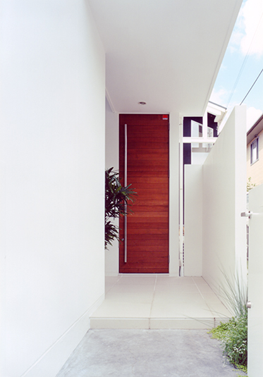 白壁に一際目立つ木製の玄関ドア