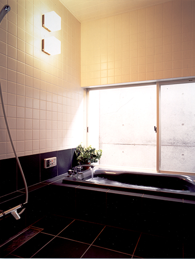 黒のバスタブにコンクリートの壁がシックな浴室