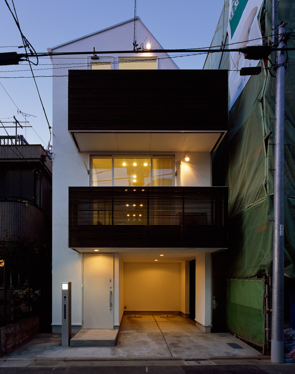 ルーバーの隙間から見えるぼんやりと灯される光が魅力的な夜の外観