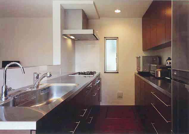 ステンレス素材と焦げ茶の木目で統一した、清潔感あるキッチン