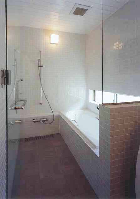 壁面からタイルを使用し、清潔感のあるシンプルな浴室