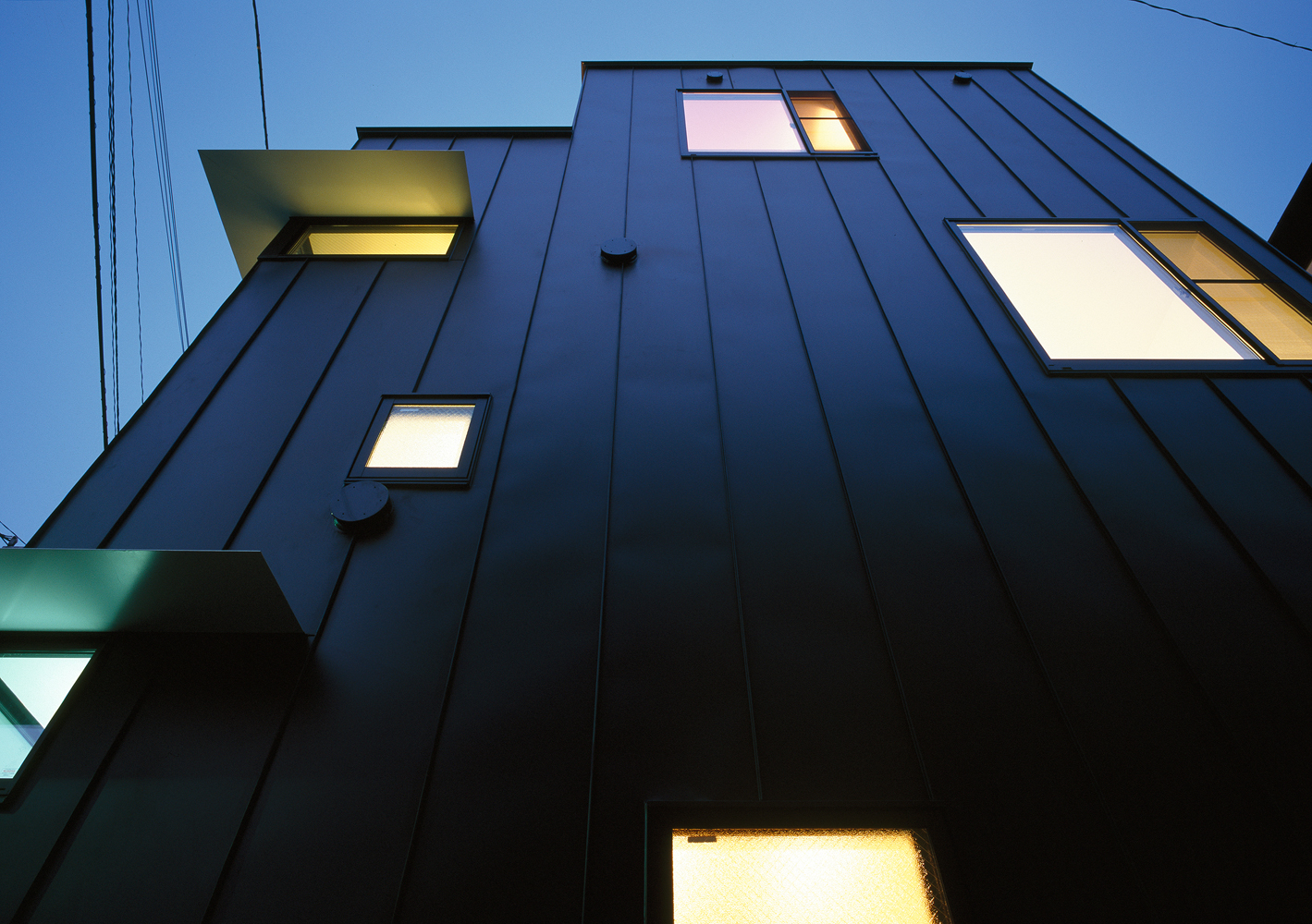 庇を薄めの一枚板にし、エッジの効いたイメージに仕上げた西面外観