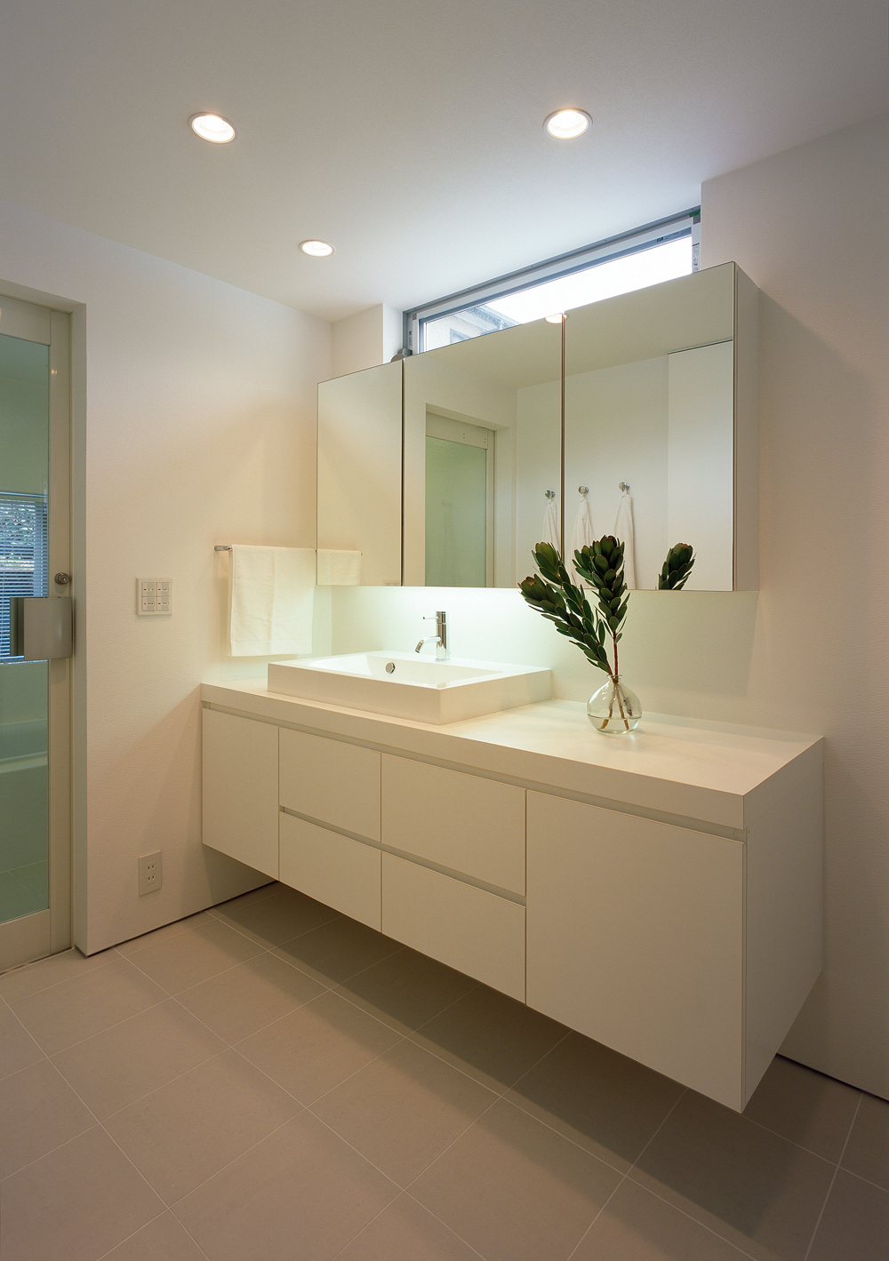 ハイサイドから爽やかな風と光りが入る、白でまとめた広々とした洗面所