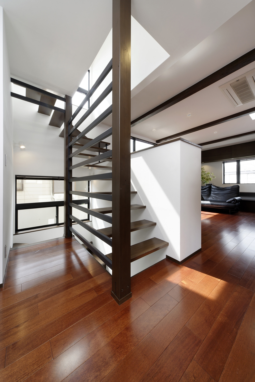 片側の壁面をスポーク上にした、躍動感溢れる階段