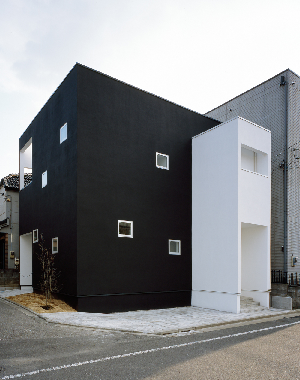 住宅地というキャンパスに、黒い箱と白い箱をそっとおいた家