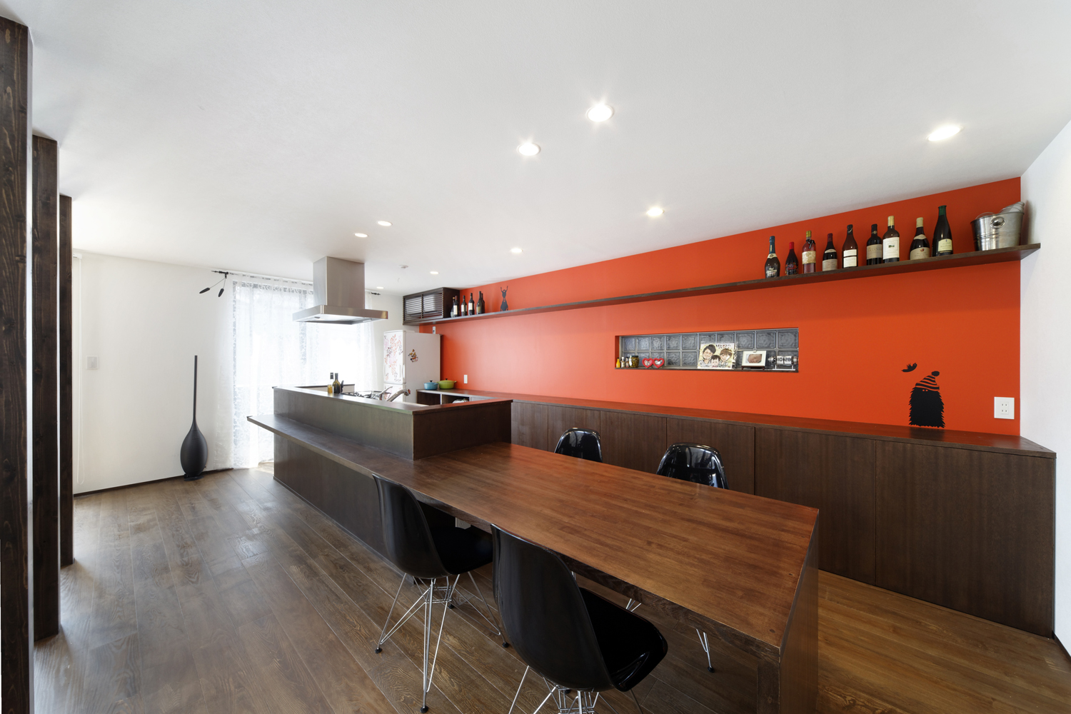 食欲を増す朱色の壁面が、焦げ茶色でまとめた空間にインパクトを与えるキッチン