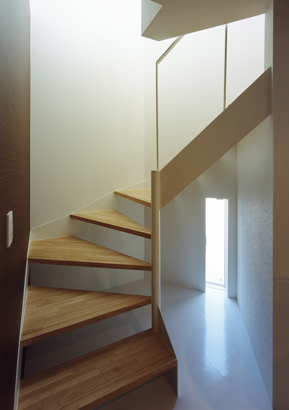 階段下の小さな細長い小窓が、光と風を運び入れる階段周り