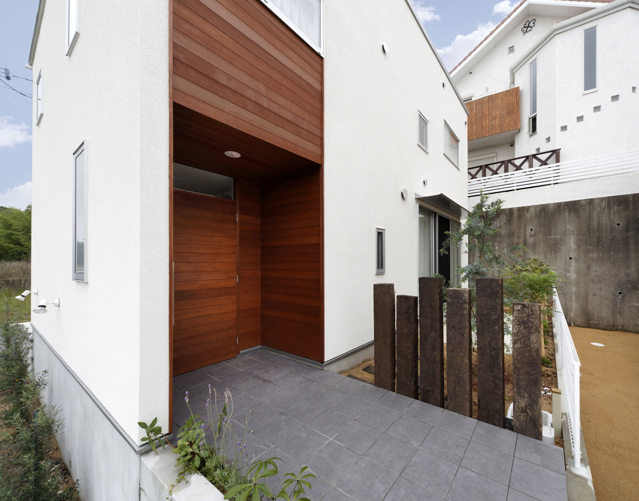 庭の目隠し代わりに、ランダムな高さで配置された枕木の塀