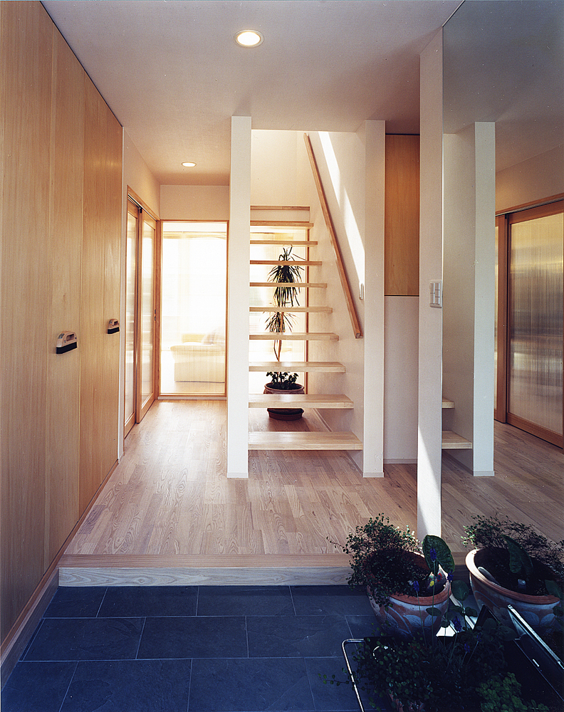 ポリカーボネートでできた各部屋の引き戸から、優しい光が入り込む玄関ホール