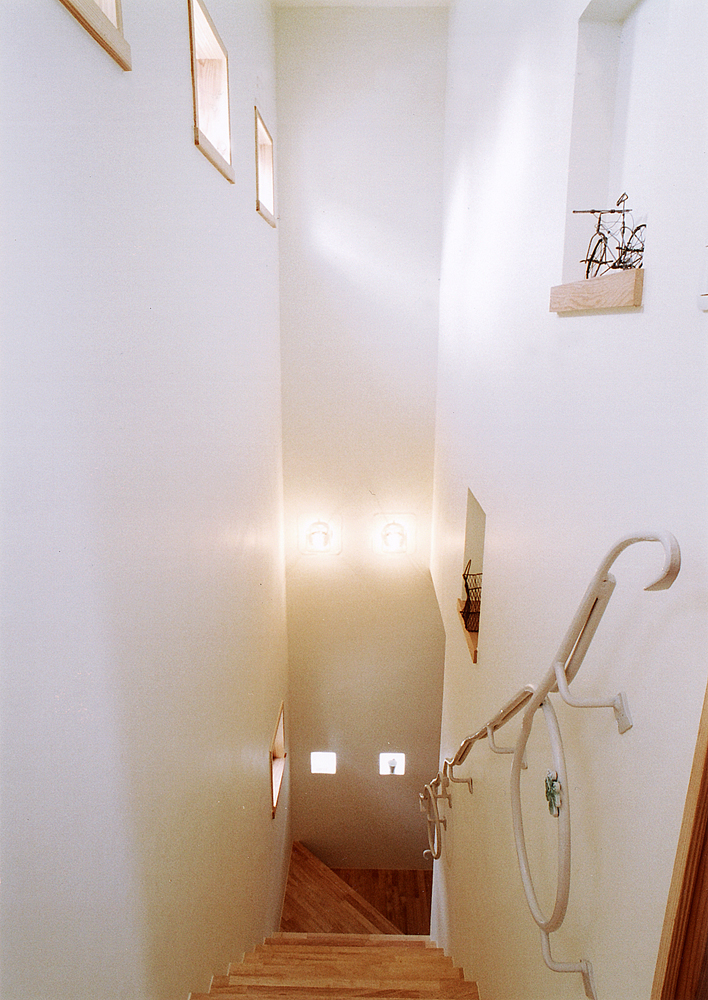 遊び心満載な白いアイアンの手すりが、優しい空間を生み出す階段