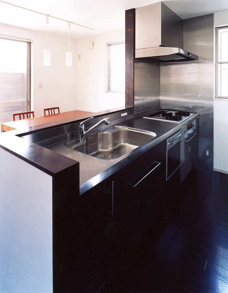 シックな焦げ茶色とステンレスカラーでまとめた、動きやすいキッチン