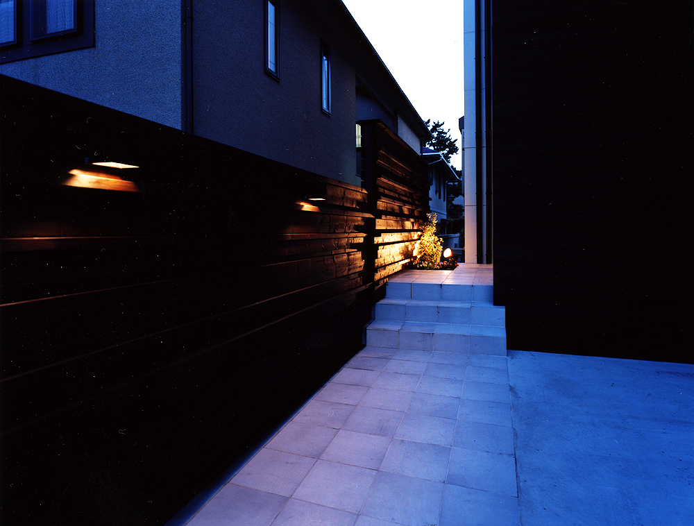 外壁の焼杉の素材感、玄関ホールまで続く柔らかい光が、日本の美を感じるアプローチ