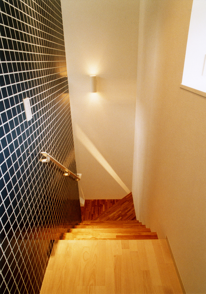 黒タイル壁・ステンレス手すりで、男前な空間に作り上げられた階段
