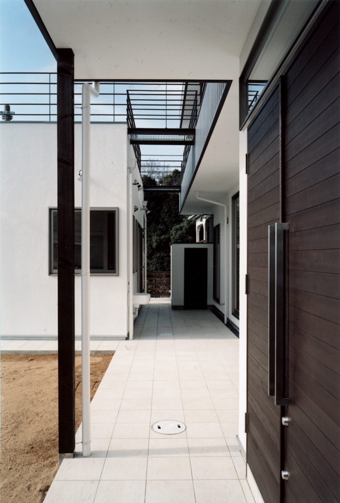 屋上テラスに向かうブリッジ下は、光と影を楽しめるスペースになる1階デッキ