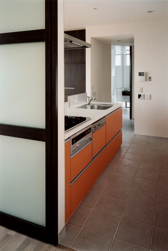 食欲を満たす料理を提供できそうな、側板のオレンジ色が魅力的なキッチン