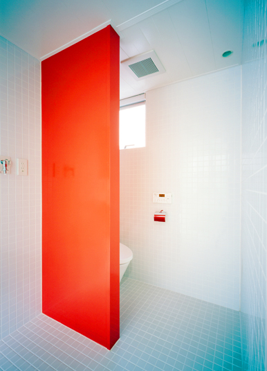 インパクトのある朱い壁が特徴の水まわり