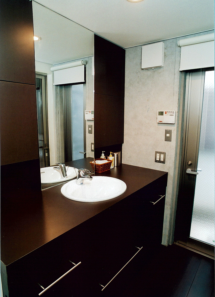 黒でまとめた大人の空気が漂う、コンクリート壁とマッチした洗面所