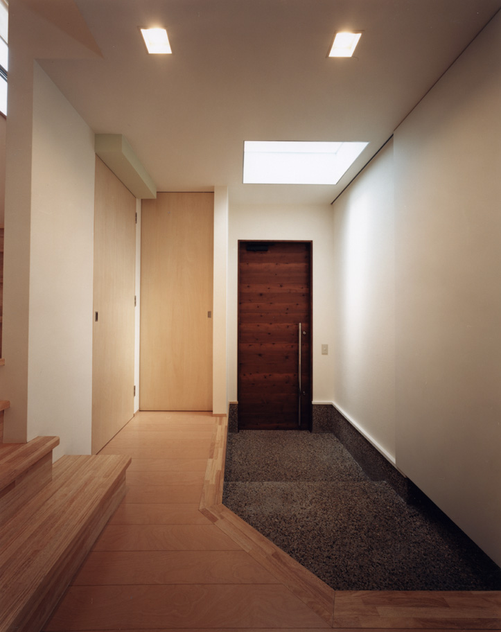 玄関ドアを開けると、トップライトからのみの光が優しくフロアを包み込む玄関ホール