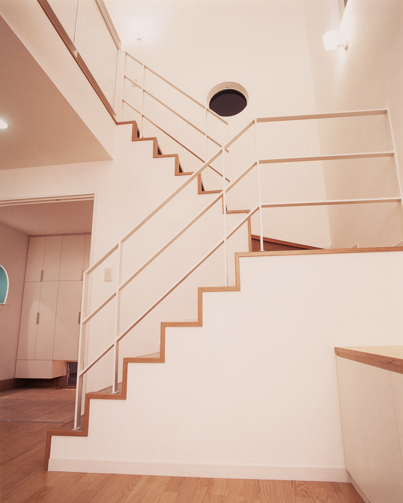 丸窓が似合う、シンプルなラインで構成された美しい階段