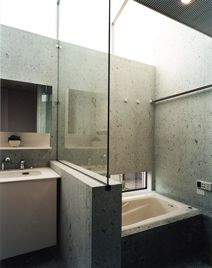 石の風合いを活かした、ハイサイドウインドウから美しい光が入る、クールでシャープな浴室