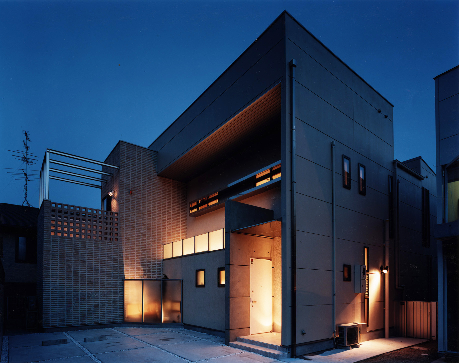 外壁の一部をテラコッタを使用した、隠れ家バーのようなデザイン性の高い夜の外観