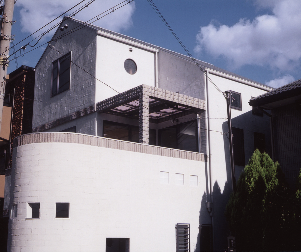 小窓使いとタイルの使い方がかわいらしい、白を基調とした外観