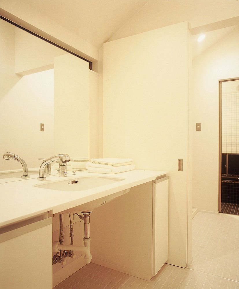 脱衣室と洗面所に仕切りを設けた、無駄のないデザインでまとめた洗面所