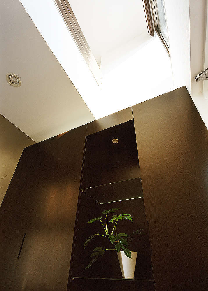 下駄箱上の吹き抜けにあるハイサイドライトが、明るさを提供する玄関