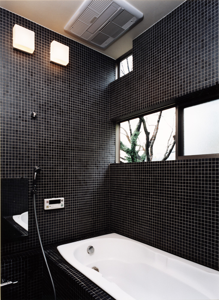黒のタイルで統一した、窓からの四季を楽しめる在来浴室