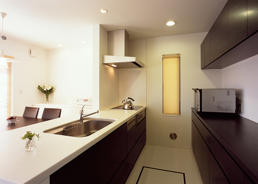 白と焦げ茶でトラッドなテイストでまとめた、無駄のないシンプルなキッチン