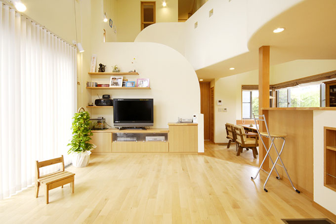 円弧状の壁がアクセントになる吹き抜けのあるリビング Fevecasa フェブカーサ