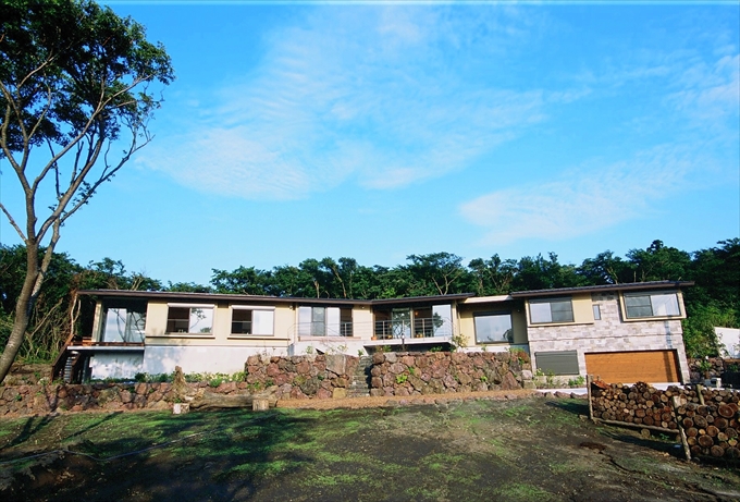 木々を背面に佇む外観