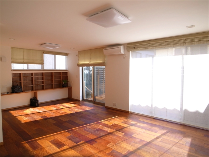 深みのある木の床を照らす窓からの光