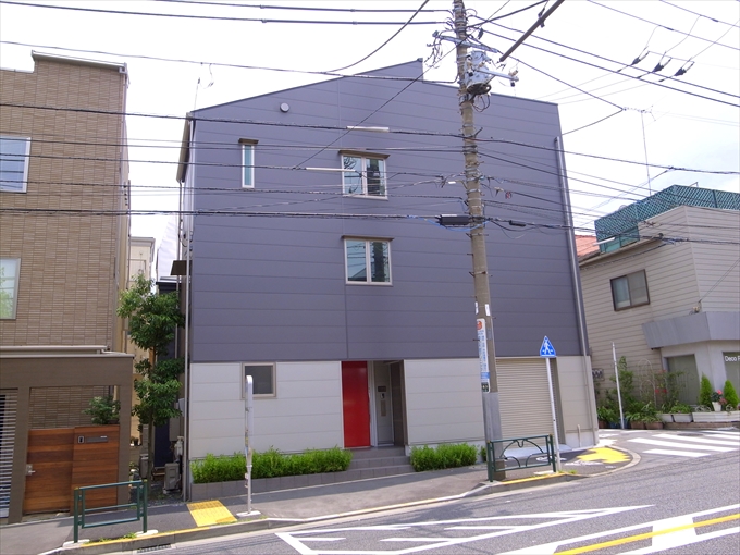 赤いドアが差し色の外観