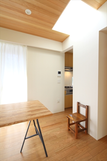 白い壁にトップライトの光が反射する明るい空間