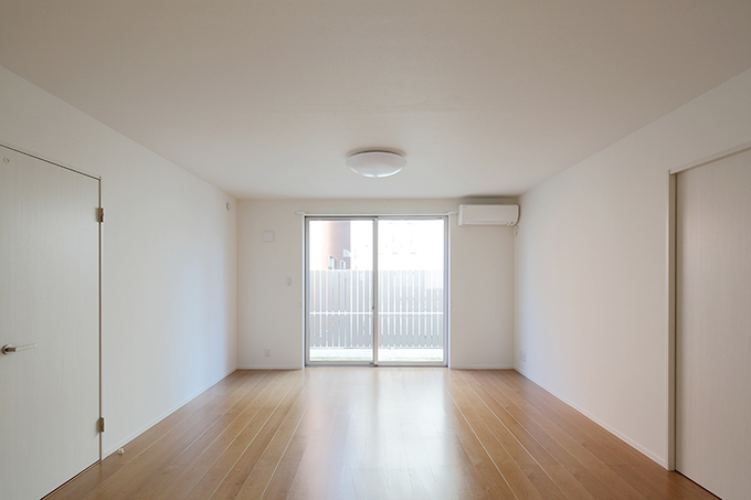 白い壁とナチュラルなフローリングのリビング