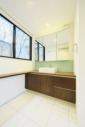 白い壁と木目調でまとめたナチュラルな洗面ルーム