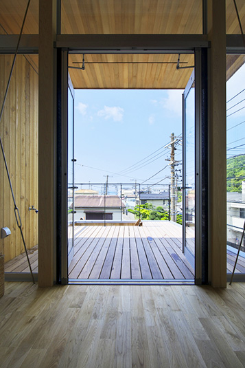 空へと開くリビングと一体となったウッドデッキ