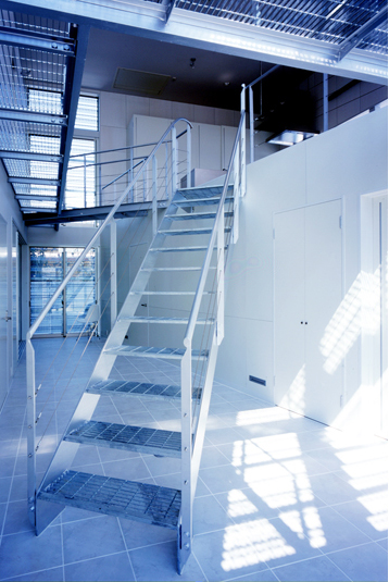 グレーチングのブリッジが架かる1Fホール空間